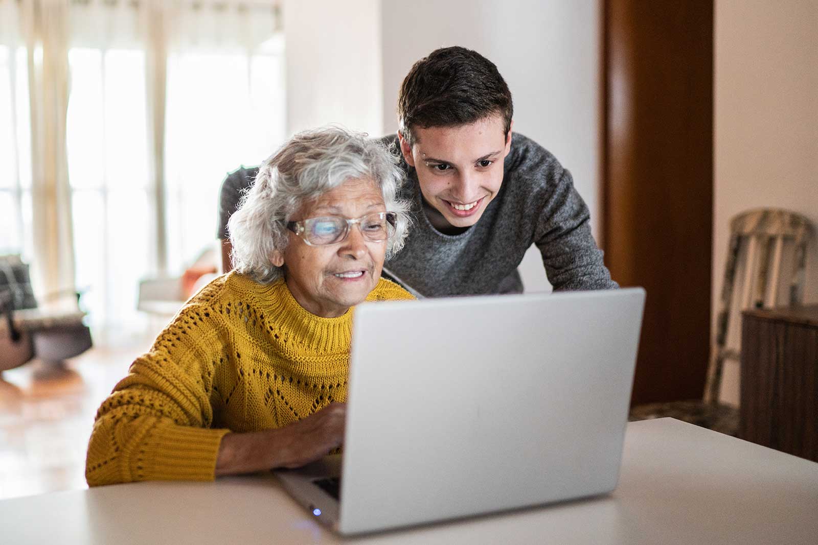 imagen del nieto ayudando a la abuela latina con el portátil
